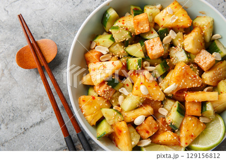 Rujak or rojak is a salad dish of a mixture of sliced fruit and vegetables and served with a spicy palm sugar dressing closeup in the bowl. Horizontal top view 129156812