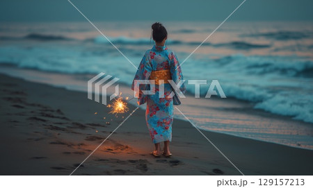 夏の夕暮れ、浴衣姿で線香花火を持つ女性の後ろ姿 129157213