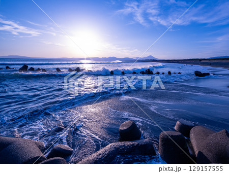荒波の打ち寄せる茅ヶ崎西浜海岸から遠くに富士山が見える風景 129157555