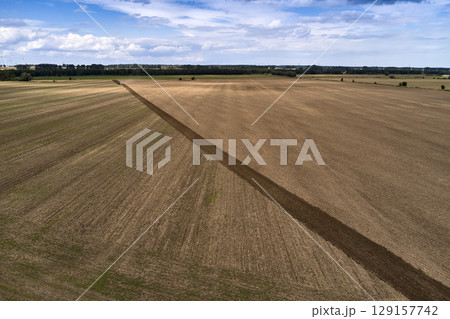 plowing farm after harvesting with vehicle 129157742