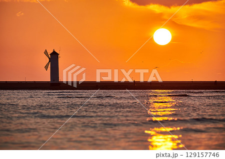 swinoujscie mills lighthouse with rising sun 129157746