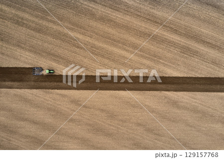 plowing farm after harvesting with vehicle 129157768