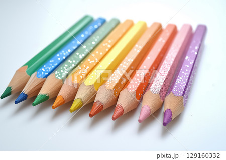 A set of rainbow-colored pencils arranged in a circular pattern on a clean white surface 129160332