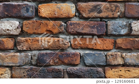 Rustic, weathered brick wall with varied colors and mortar lines. Natural building texture background. Seamless tile. 129160681