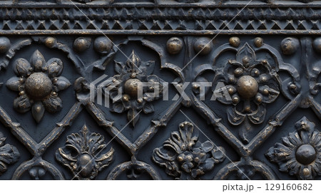 Close-up of a dark vintage forged iron gate with ornate floral pattern details. Seamless tile. 129160682
