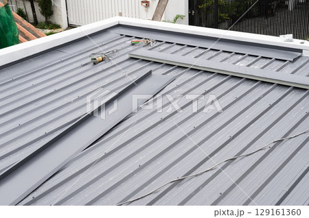 Gray corrugated metal sheet roofing. Durable metal material building exterior sturdy weather protection. Polyurethane pu foam insulation beneath adds energy efficiency sound dampening 129161360