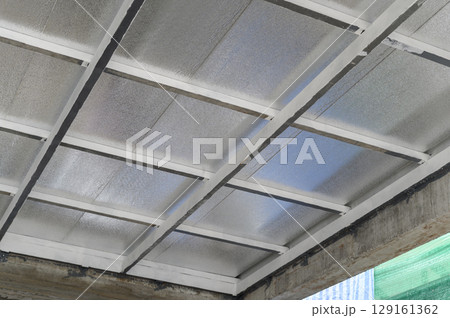 Modern ceiling construction uses metal framing panels featuring composite sheet material built with pu foam insulation for energy efficiency. modular design creates patterned surface texture Modern ceiling construction uses metal framing panels featuring composite sheet material built with pu foam insulation for energy efficiency. modular design creates patterned surface texture 129161362