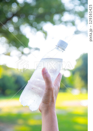 手にペットボトルの冷たい水　ミネラルウォーター　暑い夏 129161425