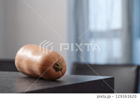 Whole butternut squah on concrete countertop Whole butternut squah on concrete countertop 129161620