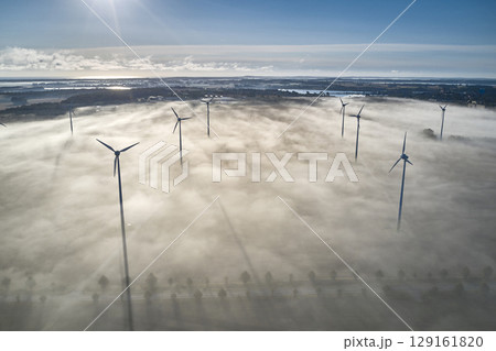 onshore wind turbine standing in fog in the morning sun 129161820