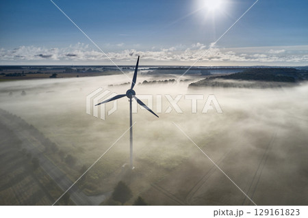 onshore wind turbine standing in fog in the morning sun onshore wind turbine standing in fog in the morning sun 129161823