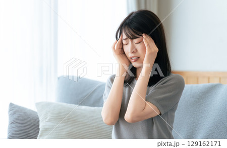 頭を押さえて悩む女性 129162171
