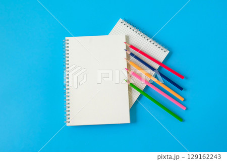 Top view of notebook and color pencil on background. 129162243