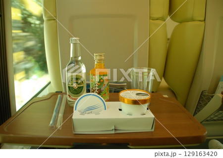 新幹線車内のトレイに並ぶドリンクと駅弁 129163420