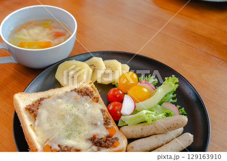 ミートトーストとウインナー、サラダやスープが揃った洋風朝食セット 129163910