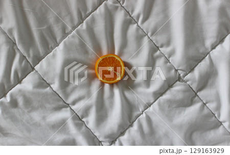 Half of fresh orange on a clean white blanket stock photo for backgrounds Half of fresh orange on a clean white blanket stock photo for backgrounds 129163929