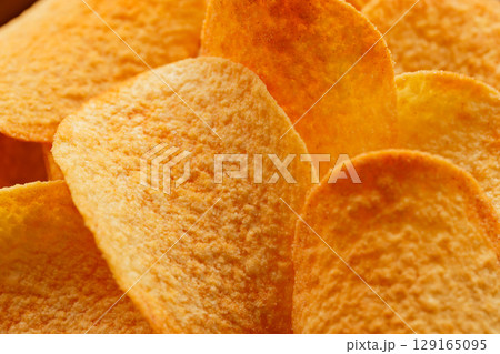 Close-Up of Golden Potato Chips with Oily Texture and Flavor 129165095