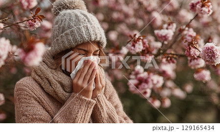 Woman Blowing Nose in Spring Blossom Allergy Season Woman Blowing Nose in Spring Blossom Allergy Season 129165434