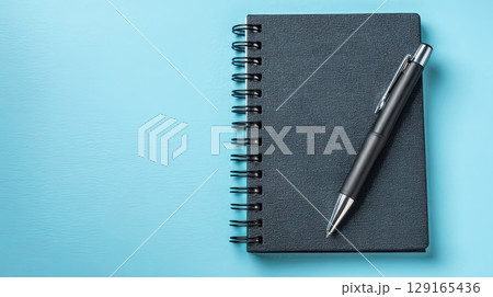 Black Notebook and Pen on Light Blue Background Black Notebook and Pen on Light Blue Background 129165436