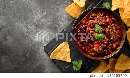 Spicy Chili Con Carne with Tortilla Chips on Slate 129165749