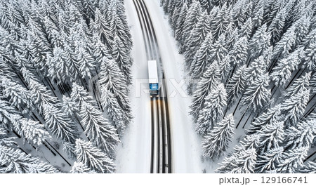 Aerial View Of A Semi Truck On A Snow Covered Road Through A Dense Winter Forest 129166741