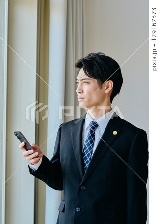 スマホを操作する20代の若い弁護士 129167373