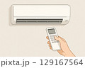エアコンのリモコンを持ち操作する手 129167564