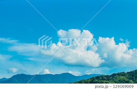 夏の青空と白い雲と山並み 129169009
