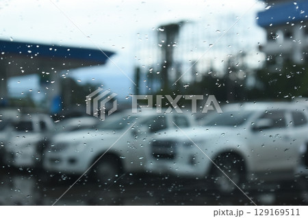 water drop on mirror in defocused car parking background 129169511