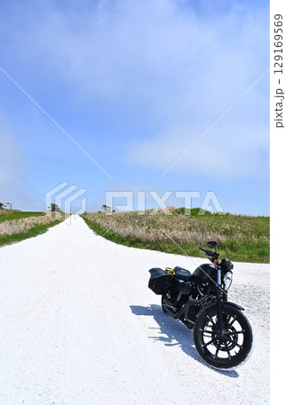 北海道の白い道を走るアメリカンバイク 129169569