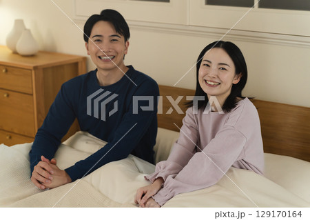 ベッドの上で会話をする夫婦　ライフスタイルイメージ 129170164