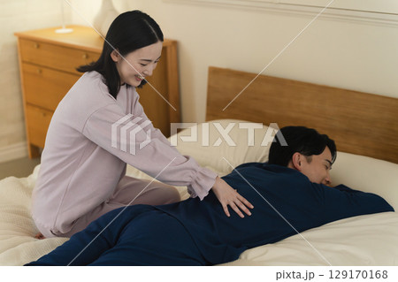 若い男性の腰をマッサージする若い女性　ライフスタイルイメージ 129170168