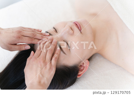 エステティシャンに施術を受ける若い女性　ビューティイメージ 129170705