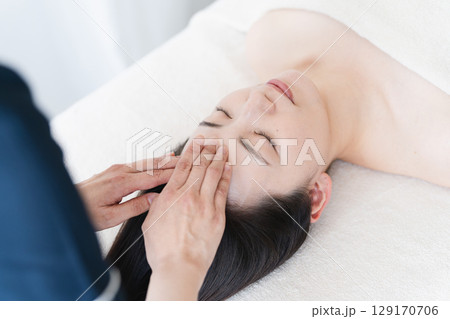 エステティシャンに施術を受ける若い女性　ビューティイメージ 129170706