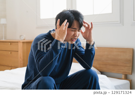 頭痛を覚える寝起きの若い男性　ライフスタイルイメージ 129171324