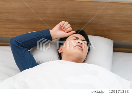 うなされながら眠る若い男性 ライフスタイルイメージ うなされながら眠る若い男性 ライフスタイルイメージ 129171358
