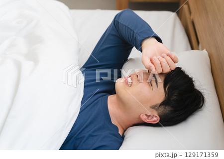 うなされながら眠る若い男性 ライフスタイルイメージ うなされながら眠る若い男性 ライフスタイルイメージ 129171359