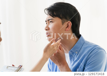 ひげ脱毛する若い男性をカウンセリングをするセラピスト 129171418