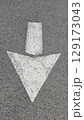 White painted arrow on asphalt road surface, representing direction and navigation in transportation contexts. 129173043