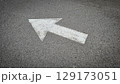 White painted arrow on asphalt road surface, representing direction and navigation in transportation contexts. 129173051