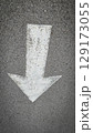 White painted arrow on asphalt road surface, representing direction and navigation in transportation contexts. 129173055