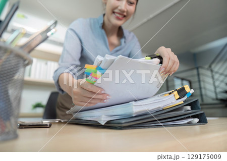 Office Worker Organizing Documents with Colorful Tabs 129175009