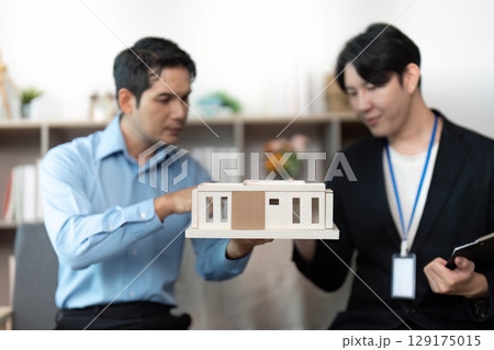 Property Presentation. Professionals analyzing a model house during a real estate meeting. Property Presentation. Professionals analyzing a model house during a real estate meeting. 129175015
