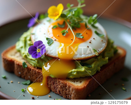 Vibrant Smashed Avocado Toast with Poached Egg and Edible Viola Flowers 129175079