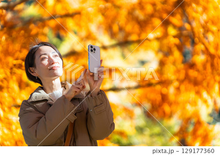 紅葉をスマートフォンで撮影している女性 ライフスタイルイメージ 紅葉をスマートフォンで撮影している女性 ライフスタイルイメージ 129177360