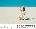 砂浜に座る水着の若い女性 129177775
