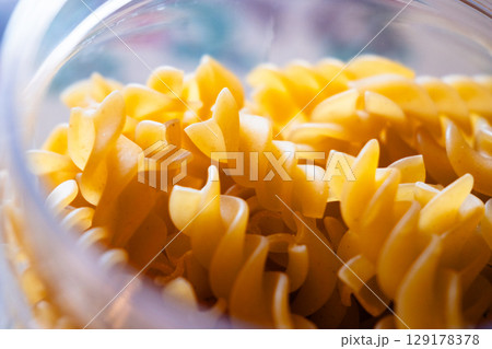 Close-up of uncooked fusilli pasta stored in the transparent glass jar Close-up of uncooked fusilli pasta stored in the transparent glass jar 129178378