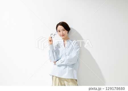 メガネを持った女性 129178680