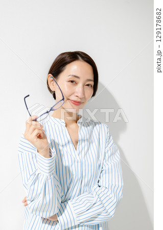 メガネを持った女性 129178682