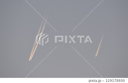 夕空を行く2機の飛行機 129178930